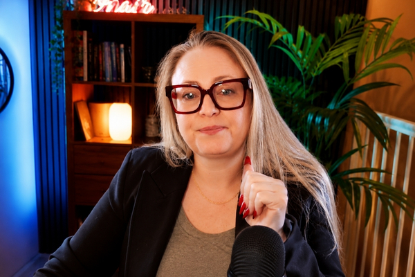 Gina Dunn, brand strategist and founder of OG Solutions, wearing red glasses and blazer in a podcast recording setup